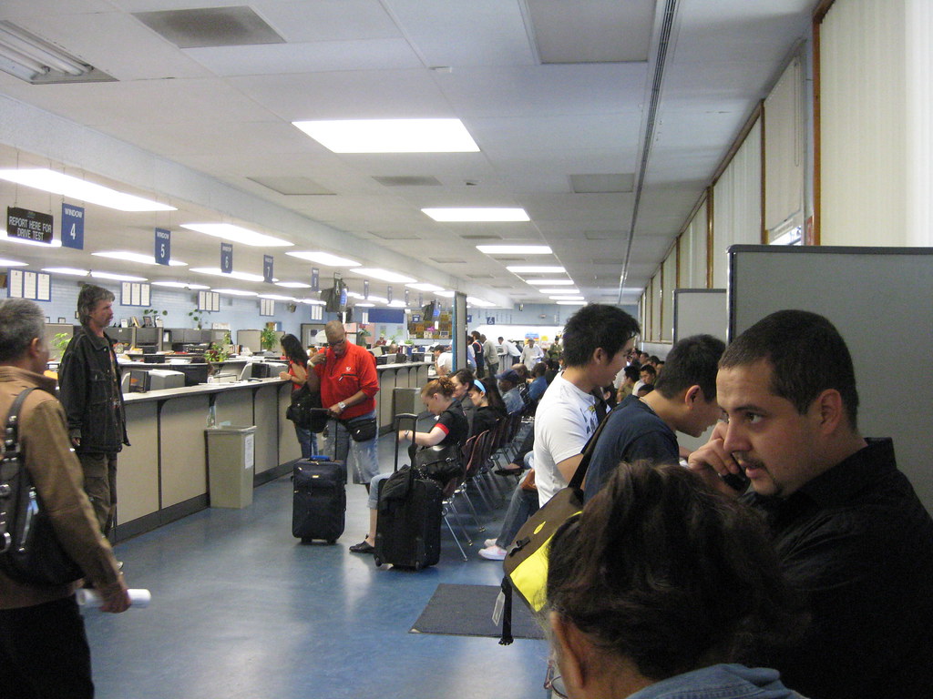 People seated in a motor-vehicle office waiting area.