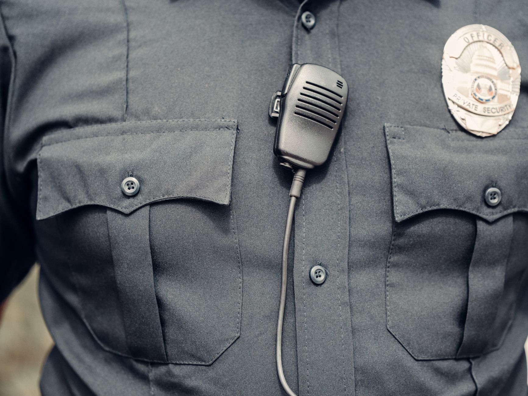Close-up of a police uniform with a body camera and badge.