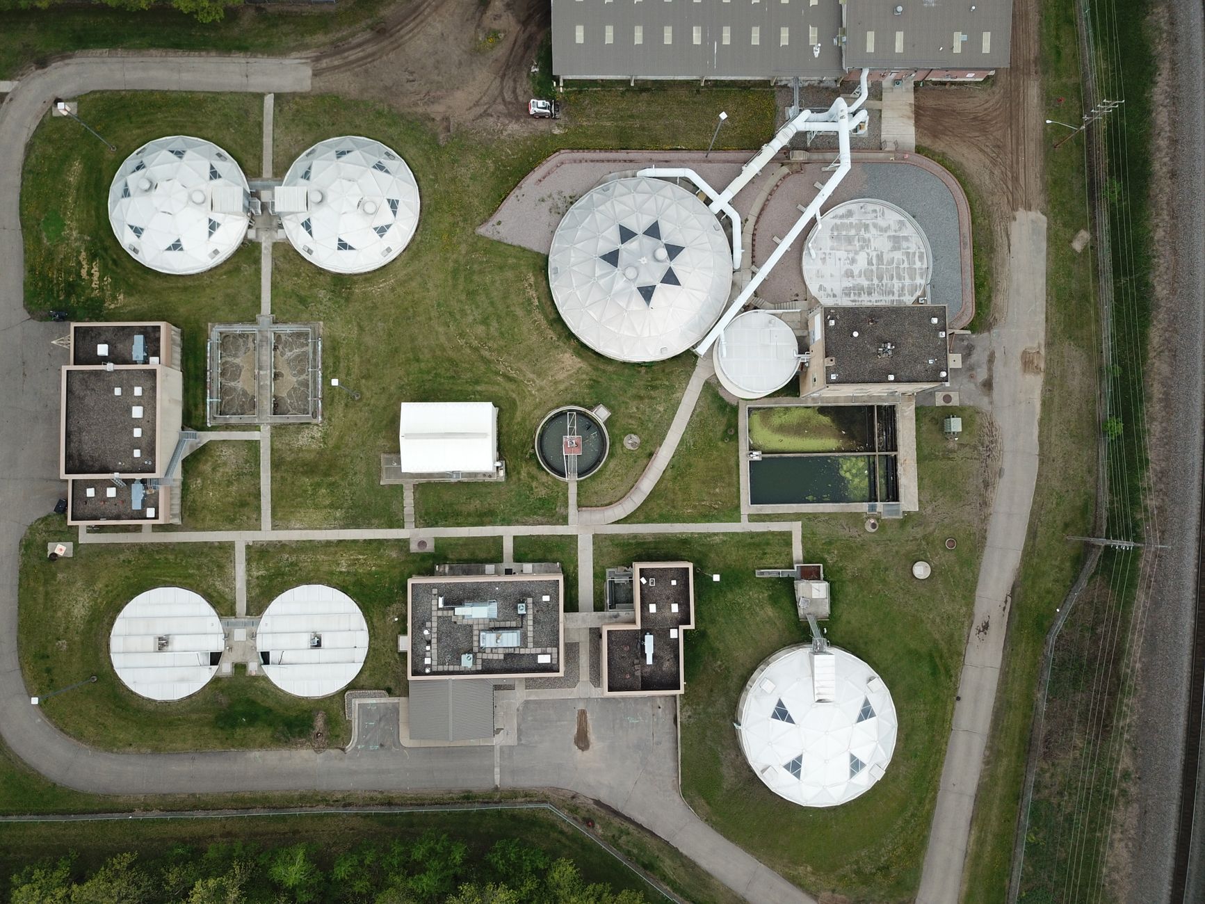 Aerial view of a municipal water-treatment plant with tanks, basins and connecting infrastructure.