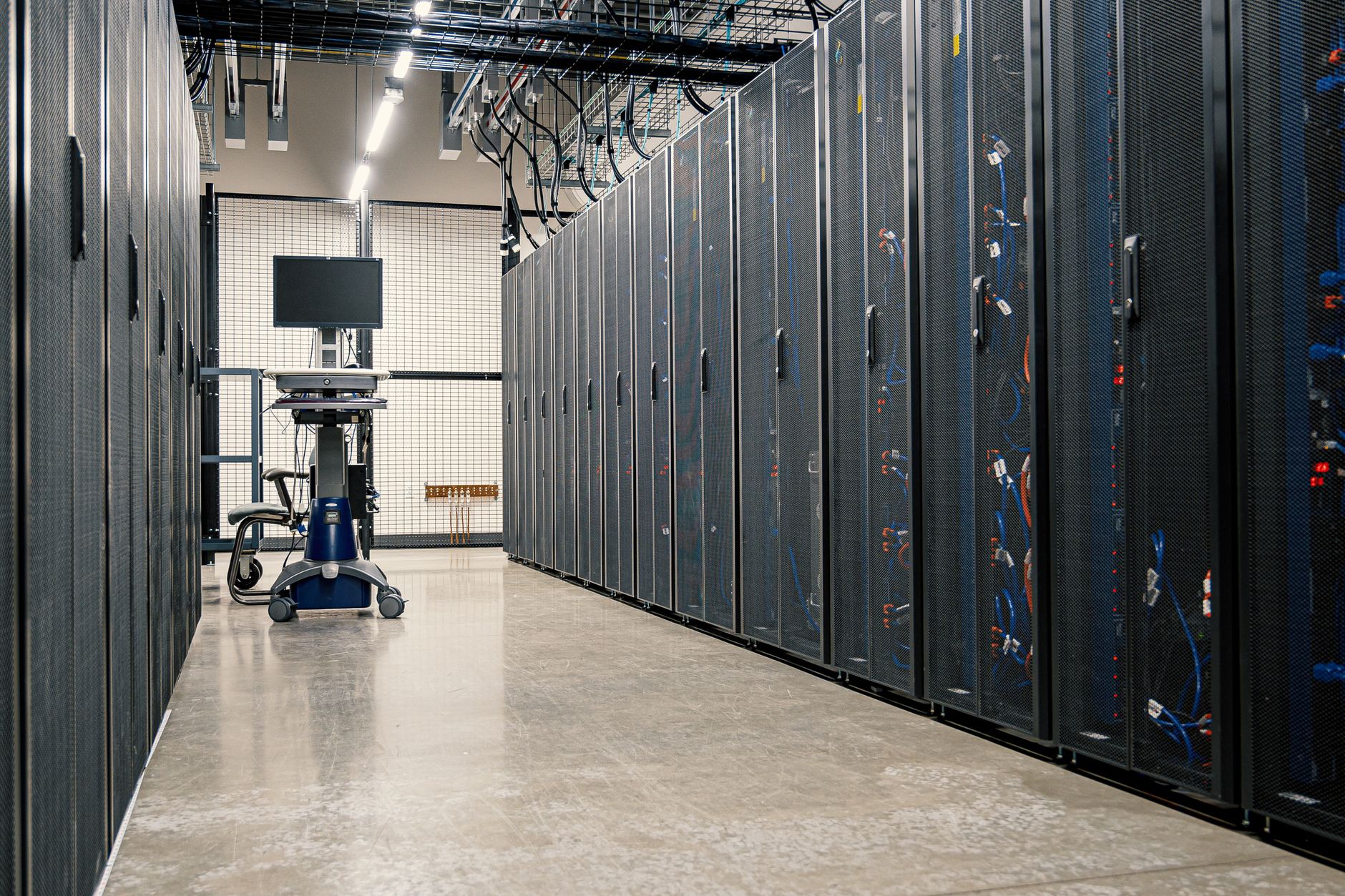 Server cabinets with networking equipment and cables in a data center.