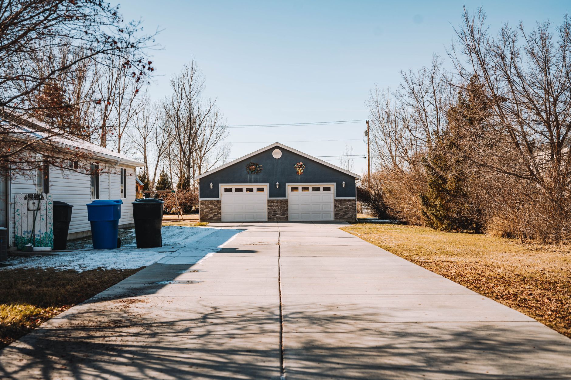 Illustrative stock image of a detached garage beside a suburban home.