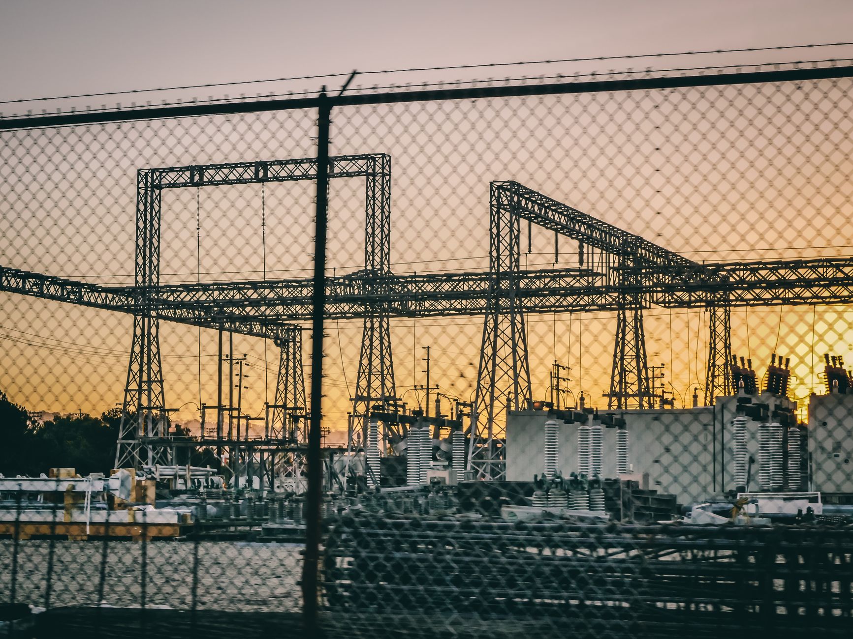 Electrical substation with fencing and power infrastructure.